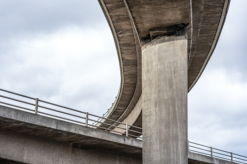 Low angle view of one elevated road over another, against an overcast sky.