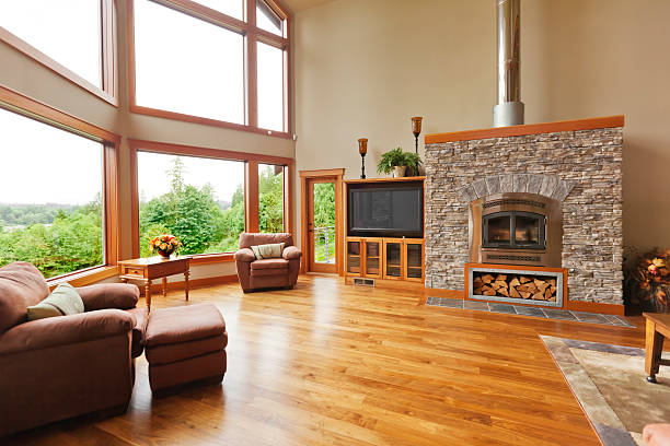 Custom Home Interior with Solid Walnut Wood Floor Custom home interior with large windows, solid walnut hardwood floor and a large fireplace. wood laminate flooring stock pictures, royalty-free photos & images