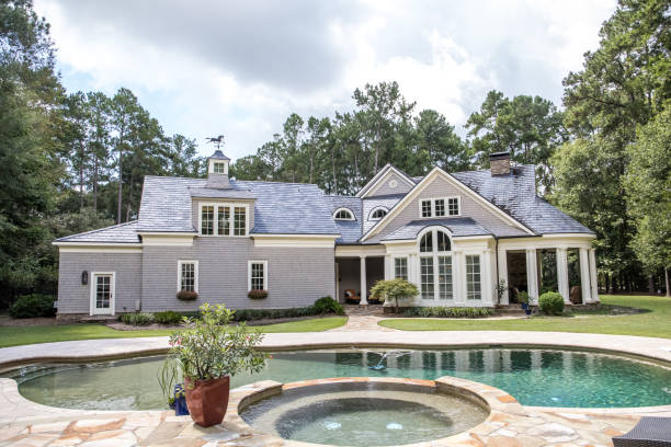 Custom pool House behind an estate with a large swimming pool Custom pool House behind an estate with a large swimming pool stone house stock pictures, royalty-free photos & images