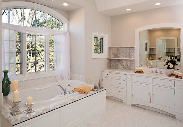 Custom white toned master bathroom with hot tub tub. stock photo
