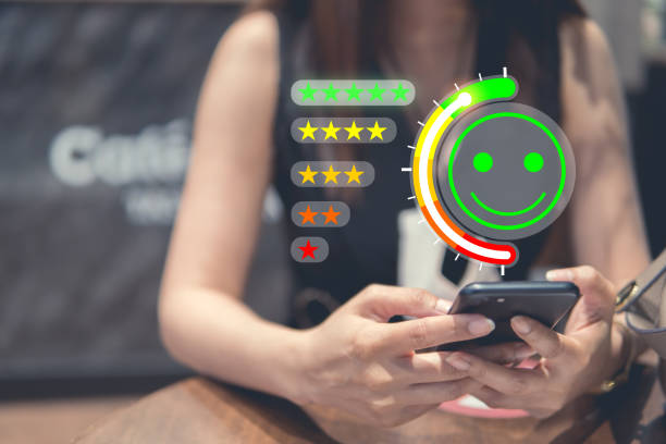 Customer Experience Concept, happy Business women holding the smartphone with visual screen of Excellent Smiley Face and Rating for a satisfaction survey. stock photo