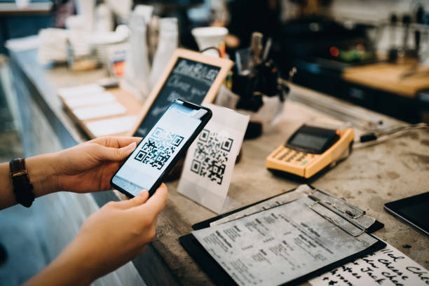 scansione del codice qr da parte del cliente, effettuando un pagamento contactless rapido e semplice con il suo smartphone in un bar - pagare foto e immagini stock