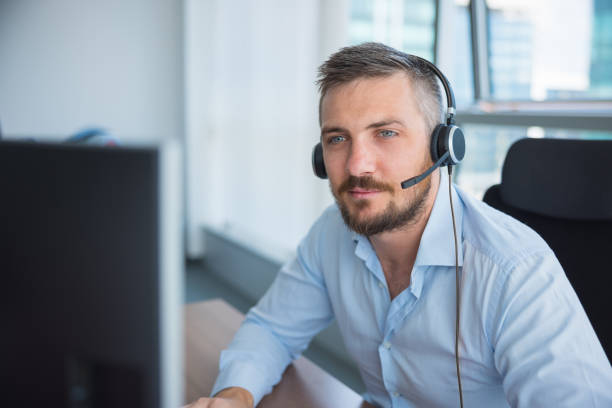Customer service agent providing assistance remotely at the desk stock photo