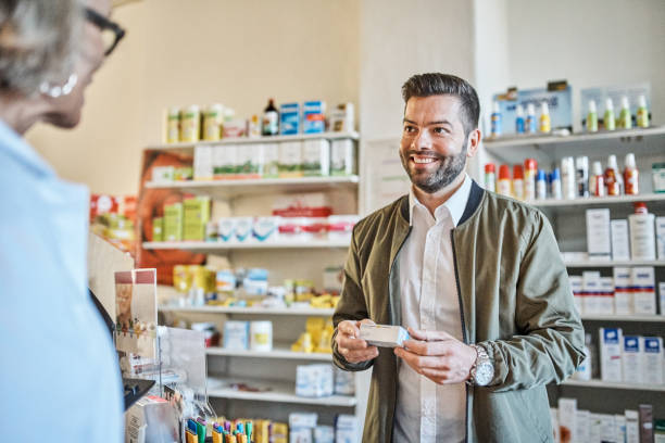 Customer talking with pharmacist at medical store stock photo