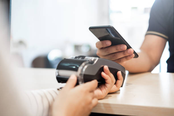 Customer using phone for payment to owner at cafe restaurant, cashless technology and credit card payment concept  paying stock pictures, royalty-free photos & images