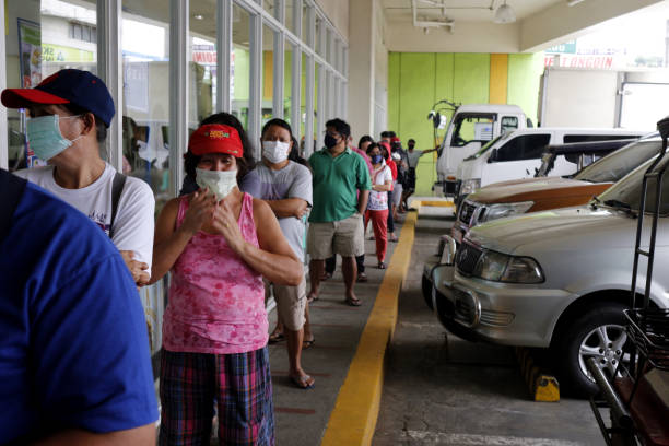 Customers line up with distance outside a store for social distancing on the Covid-19 virus outbreak stock photo