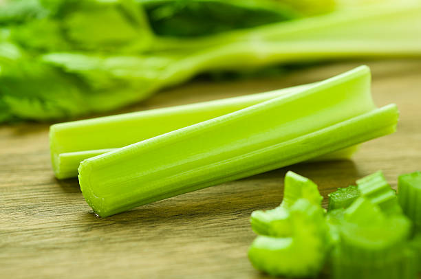 Cut celery sticks and leaves on wooden table Fresh Celery Sticks on Cutting Board celery stock pictures, royalty-free photos & images