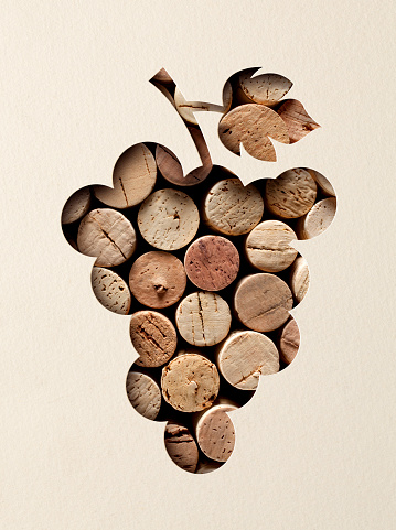 Cut paper in the shape of a bunch of grapes with wine corks.