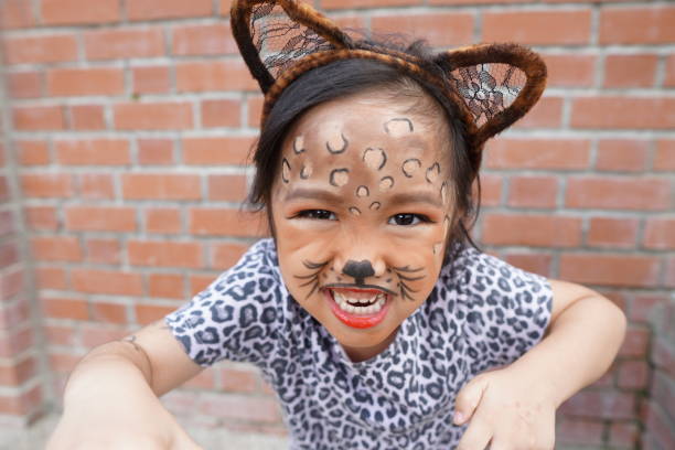 A cute 4 years old asian girl dressed up as a cheetah. stock photo
