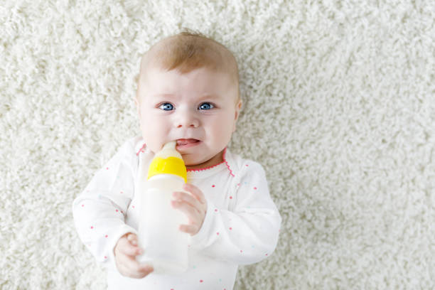 hemşirelik şişe tutan ve formül süt içme şirin yeni doğan bebek kız - baby formula stok fotoğraflar ve resimler