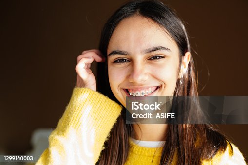 istock Cute and happy teen girl with braces smiling to camera 1299140003