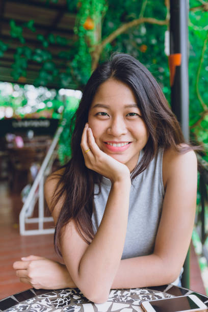cute asian Thai women portrait sitting in the cafe relax posture with dental lovely smile cute asian Thai women portrait sitting in the cafe relax posture with dental lovely smile filipino woman stock pictures, royalty-free photos & images