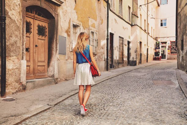 Cute attractive fashionable woman posing in the old European street. Fashion details. stock photo