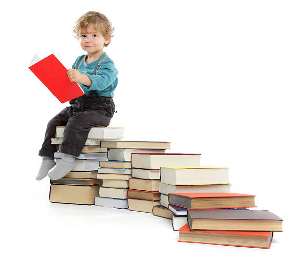 Cute baby Boy sitting on a Book Staircase stock photo