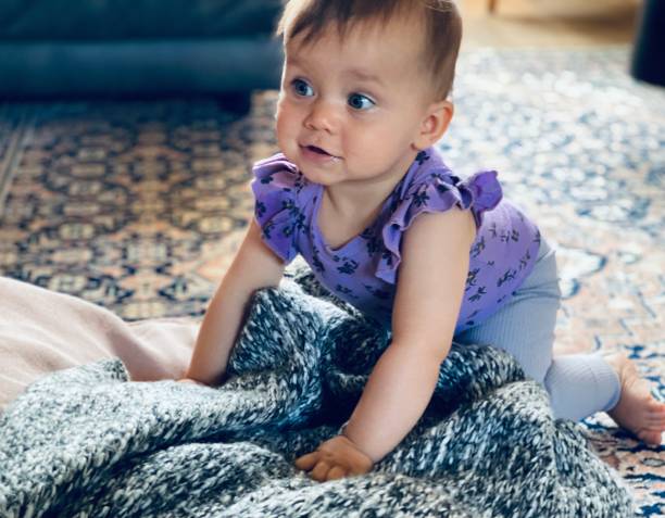 Cute baby girl playing on a  blanket stock photo