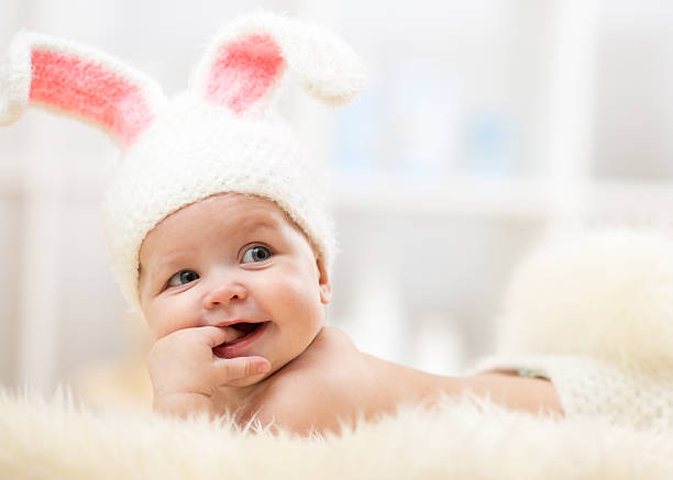 Cute baby lying on fur blanket and wearing a hat stock photo