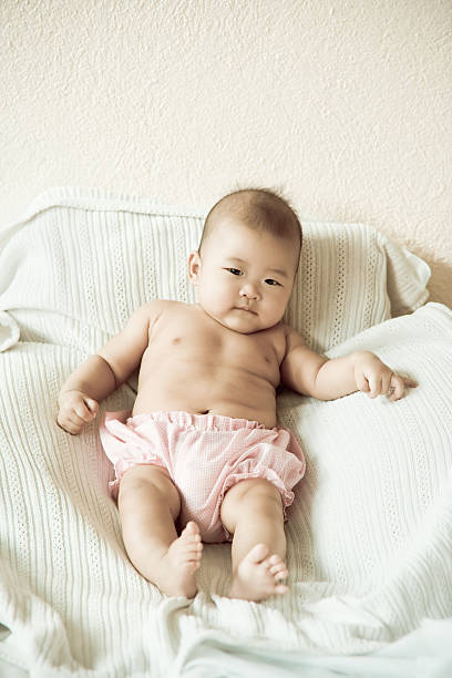 Cute baby sitting up in bed. Vintage tones.  philippines girl stock pictures, royalty-free photos & images