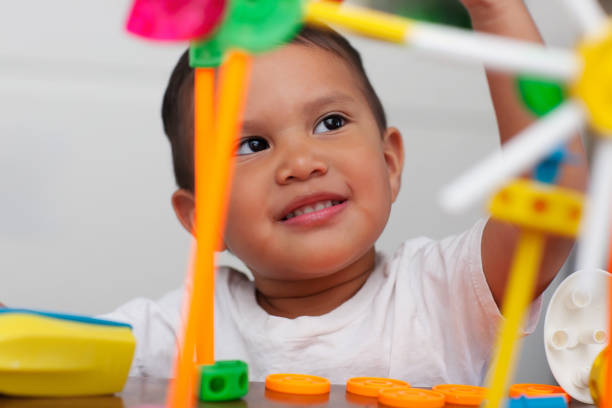A cute boy playing with preschool math manipulative toys and with a facial expression that shows wonder or thinking. A cute boy playing with preschool math manipulative toys and with a facial expression that shows wonder or thinking. 2 3 years stock pictures, royalty-free photos & images