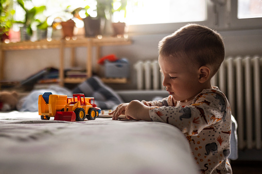 Cute toddler baby boy playing with toys