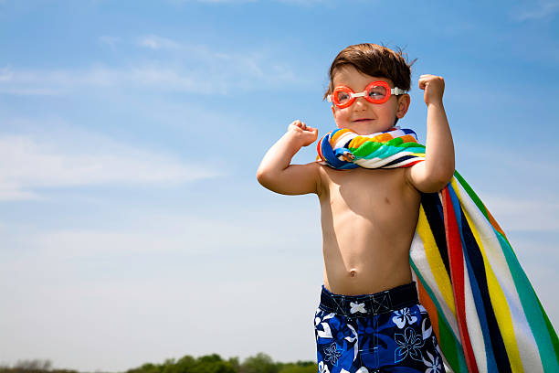 Cute Boy With Swimwear On Flexing Muscles  swimming goggles stock pictures, royalty-free photos & images