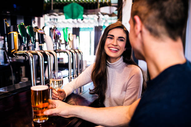 Cute couple having a drink Cute couple having a drink in a bar irish women stock pictures, royalty-free photos & images