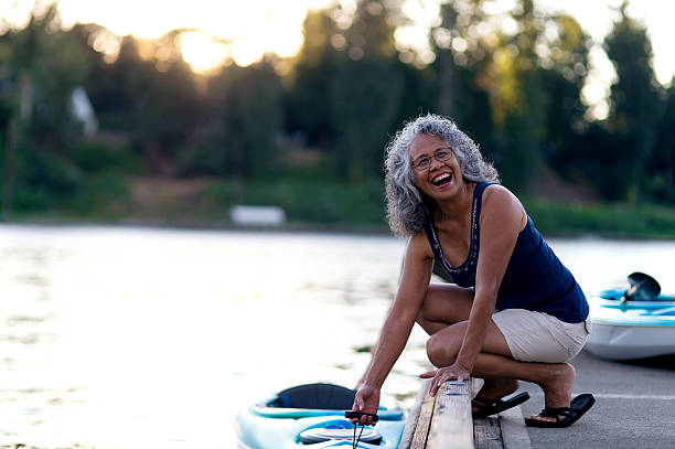 cute elderly ethnic woman ready to kayak on the river - woman kayaking bildbanksfoton och bilder