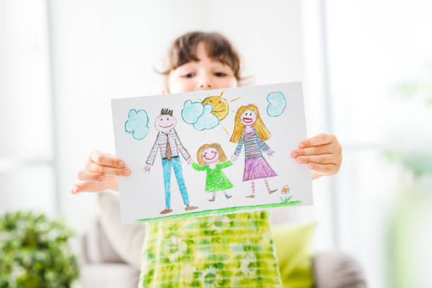 Cute girl holding a sign Cute young girl peeking behind a draw of her family, room interior on the background drawing activity stock pictures, royalty-free photos & images