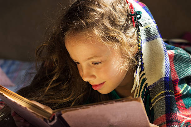 cute girl is reading a book in cold day cute curly school girl is reading a book in cold day hot latino girl stock pictures, royalty-free photos & images
