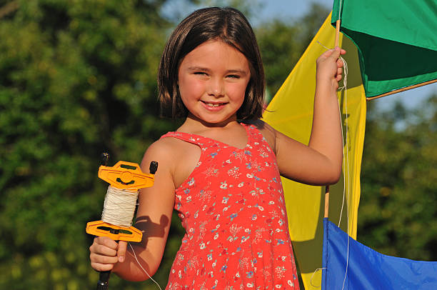 Cute girl playing with kite outside stock photo