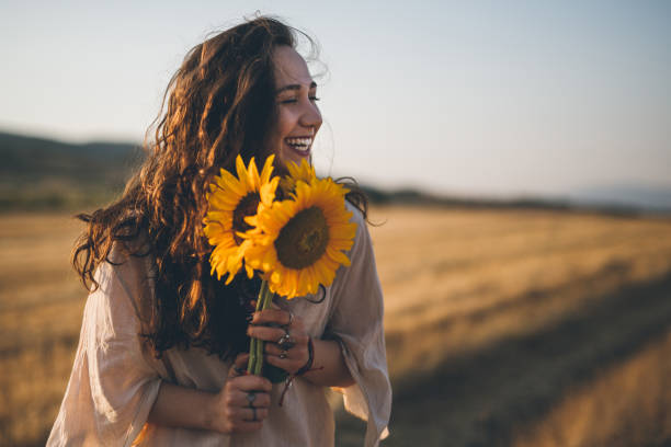 cute-hipster-girl-with-bouquet-of-sunflowers-picture-id826385458