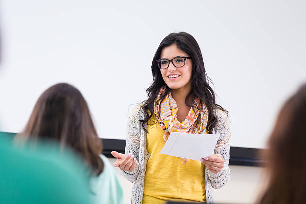 Cute hipster student reading report in front of classmates Cute hipster student reading report in front of classmates presentation speech stock pictures, royalty-free photos & images