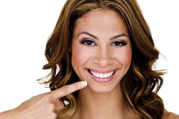 Cute Hispanic woman pointing to her smile stock photo