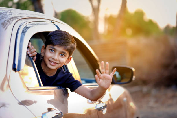 Cute Indian Child waving from car window  wave goodbye asian stock pictures, royalty-free photos & images