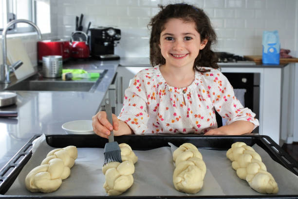 Cute Jewish girl baking sweet Challah bread for Sabbath Jewish Holiday stock photo
