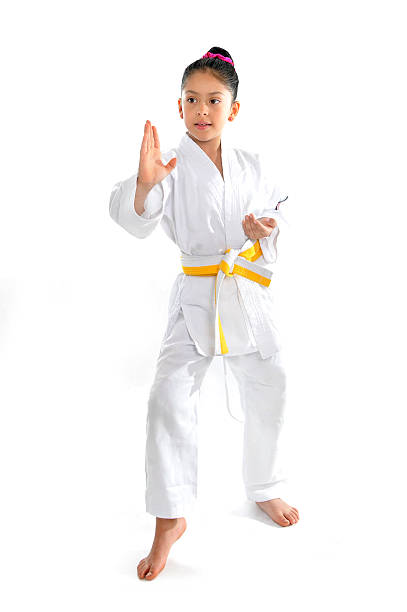 cute latin little girl in karate kimono training position stock photo