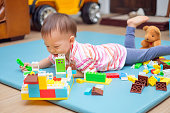 かわいい小さなアジア 18 ヶ月/1 年古い幼児男の子子供カラフルな遊んで楽しんでビルディング ブロック屋内彼が置くし、幼児の概念の教育玩具のリビング ルームでリラックス