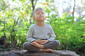 かわいい小さなアジア 2 - 3 歳幼児赤ちゃんの男の子の目を閉じると、裸足のプラクティス ヨガ ・瞑想屋外