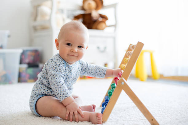 Cute little baby boy, playing with abacus at home stock photo