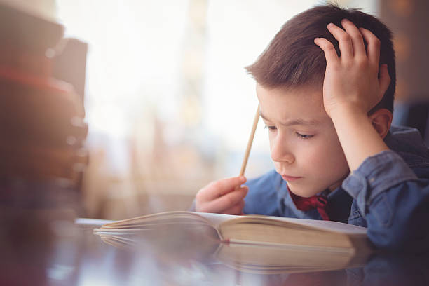 Cute little boy doing his homework stock photo