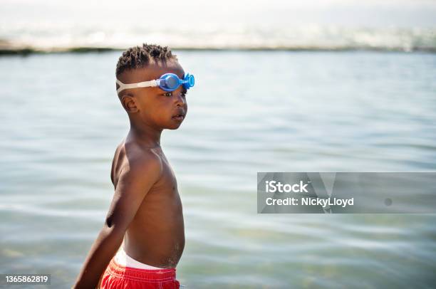 Cute little boy standing in the ocean on sunny day in summer