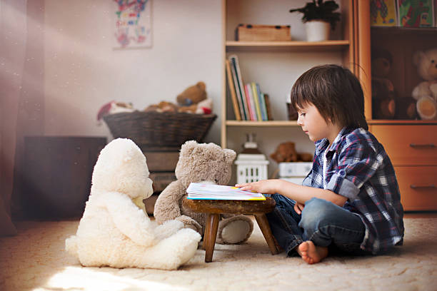 ładna małe dziecko, przedszkola chłopiec, czytanie książki - teddy ray zdjęcia i obrazy z banku zdjęć
