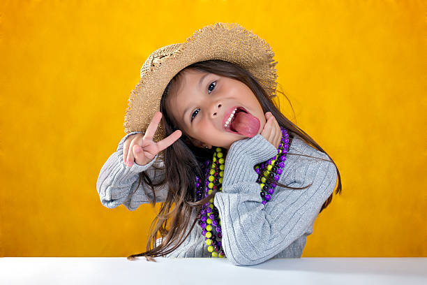 Cute little girl with hat, gray sweater and necklaces stock photo
