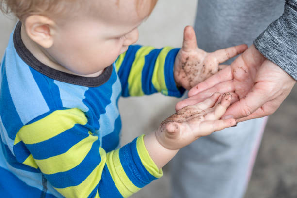 ...любопытный ребенок с грязью или - baby dirty hands стоковые фото и изобр...