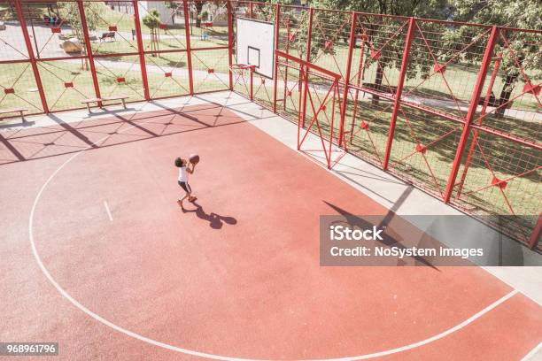Cute mixed race boy shooting hoops on basketball court