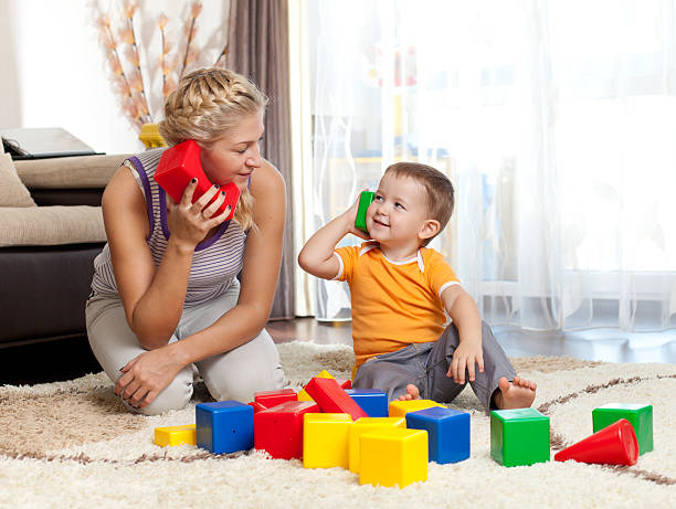 cute mother and kid boy playing together indoor stock photo