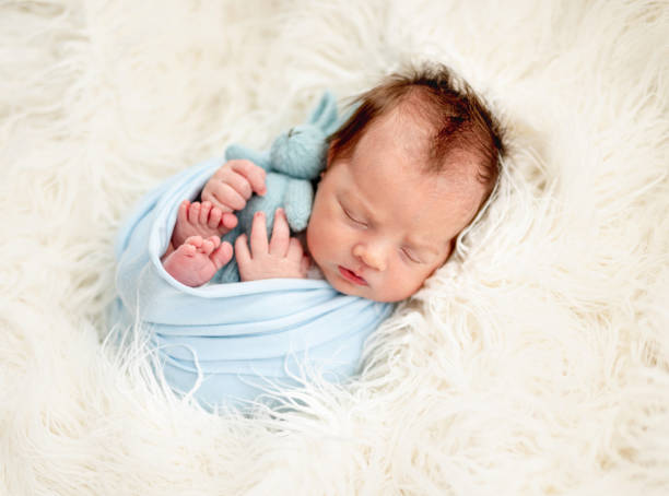Cute newborn sleeping with toy stock photo