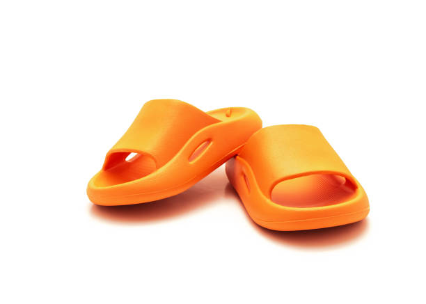 Cute pair of orange pillow slide sandals for toddler non-slip foam slippers isolated on white stock photo