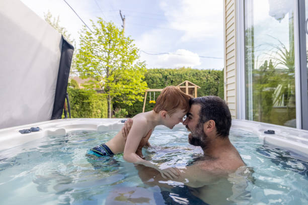 Cute Redhead Kid and Father in the Hot Tub in the Backyard in Summer stock photo