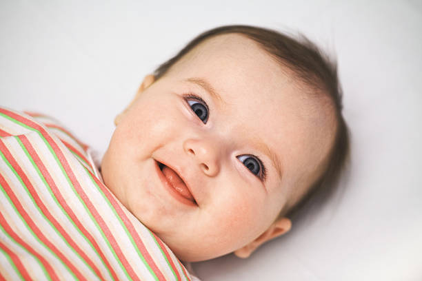 Cute smiling  baby with open blue eyes close up stock photo