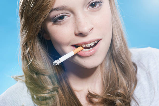 Cute teenage girl smoking cigarette close up  little girl smoking cigarette stock pictures, royalty-free photos & images